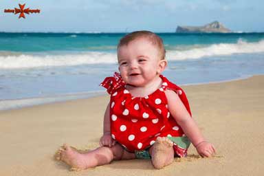 Child sitting on the beach at Waimanalo Beach Oahu Hawaii