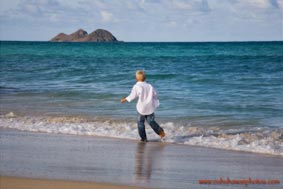 Child at play running on Waimanalo Beach 