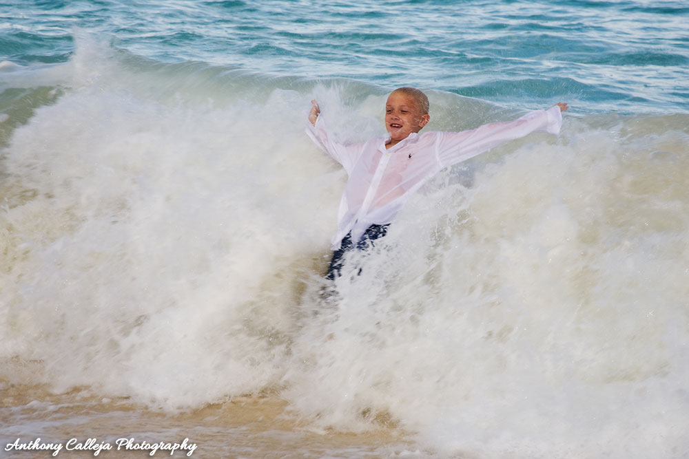 Oahu beach Photography - young boy body surfing a wave in his casual clothing